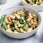 Brussels sprout pasta in a round bowl on a light backdrop with a pasta bowl in the back and small bowls