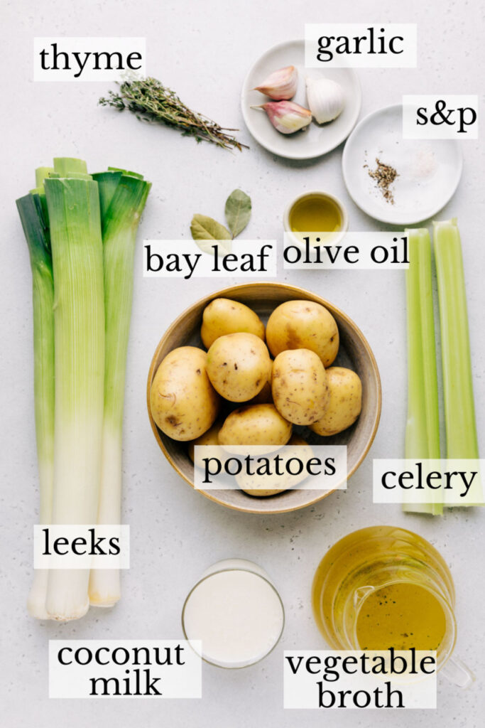 Ingredients for creamy vegan potato leek soup on a light backdrop
