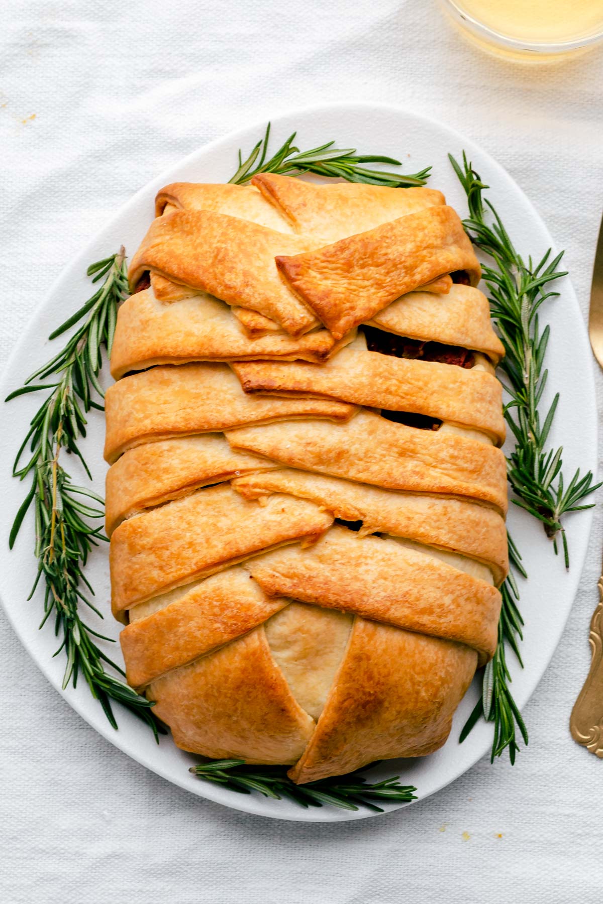 baked vegan wellington on a white plate with rosemary