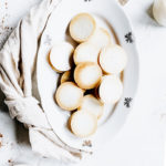 baked gingerbread bites on an oval white plate on a white backdrop with a light brown napkin
