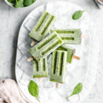 green popsicles on white plate with green leaves